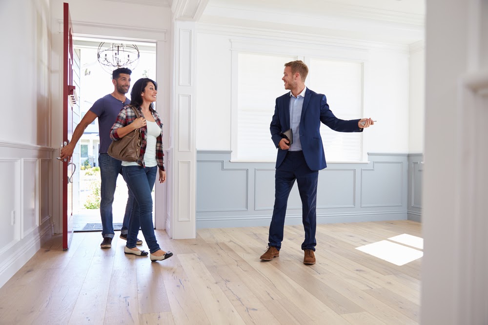 A realtor leading a couple on a tour of the house