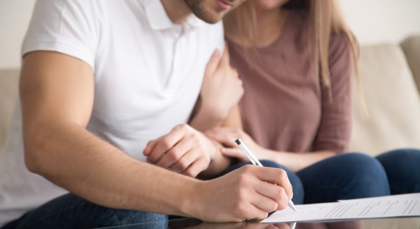 Young couple signing the closing agreement