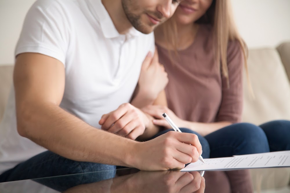 Young couple signing the closing agreement